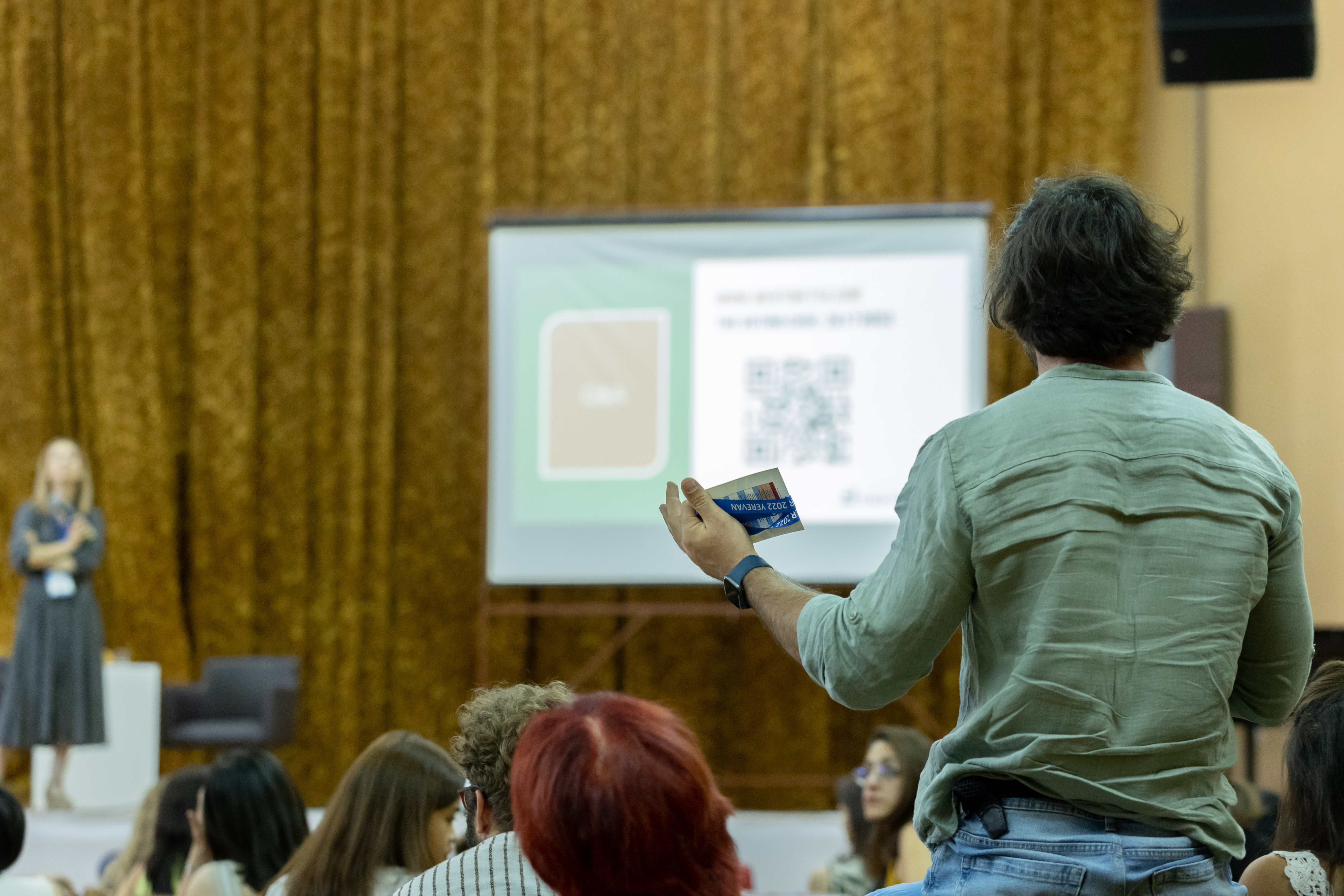 Someone from a larger audience asking a question to the main speaker.